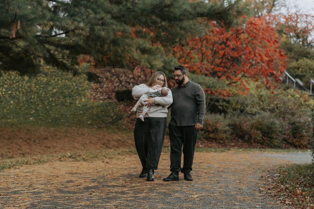 An engaged couple holding hands in the forest