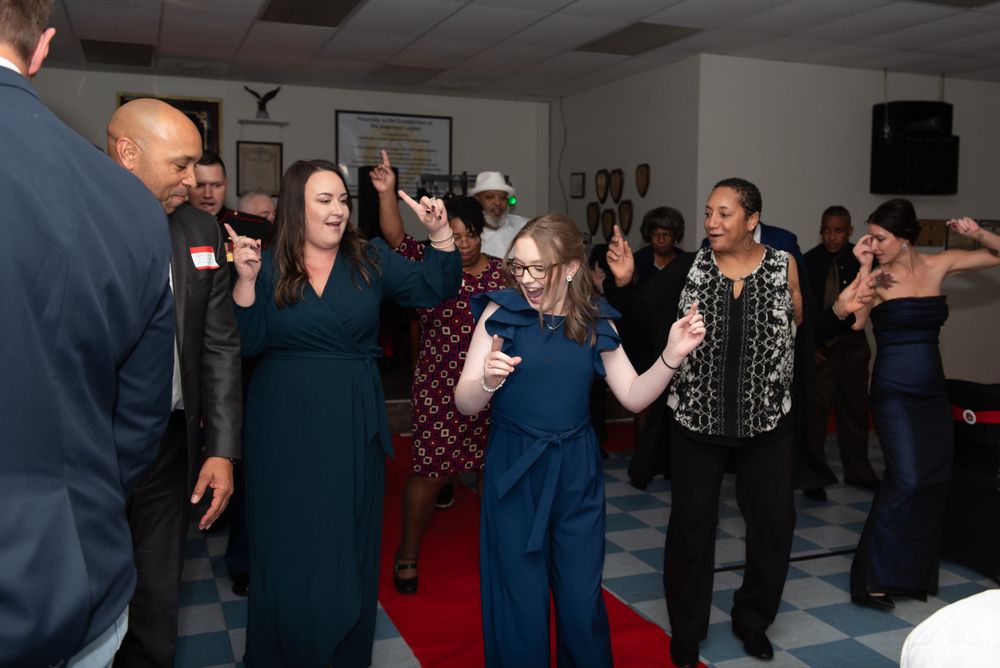 People dancing and socializing at an indoor event venue.
