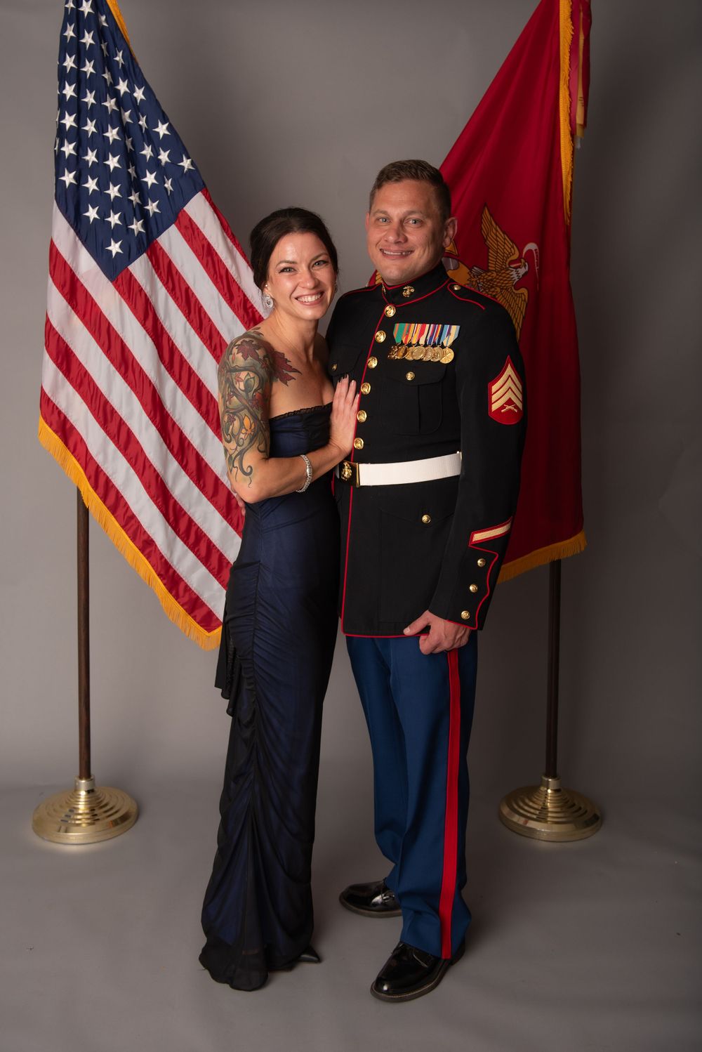 A formal portrait session with American and Marine Corps flags as backdrop.