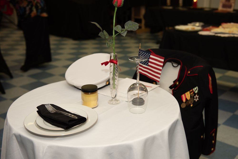 Decorated tables with American flags and place settings at a formal event.