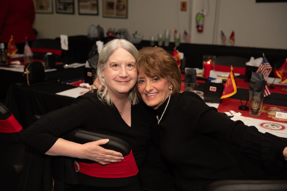 Guests enjoying themselves at a formal dinner event with red and black decor.