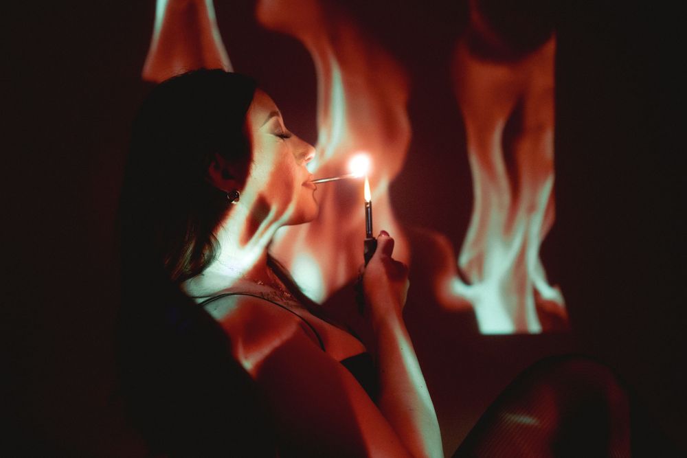 Moody portrait with match light and flame effects in darkness.