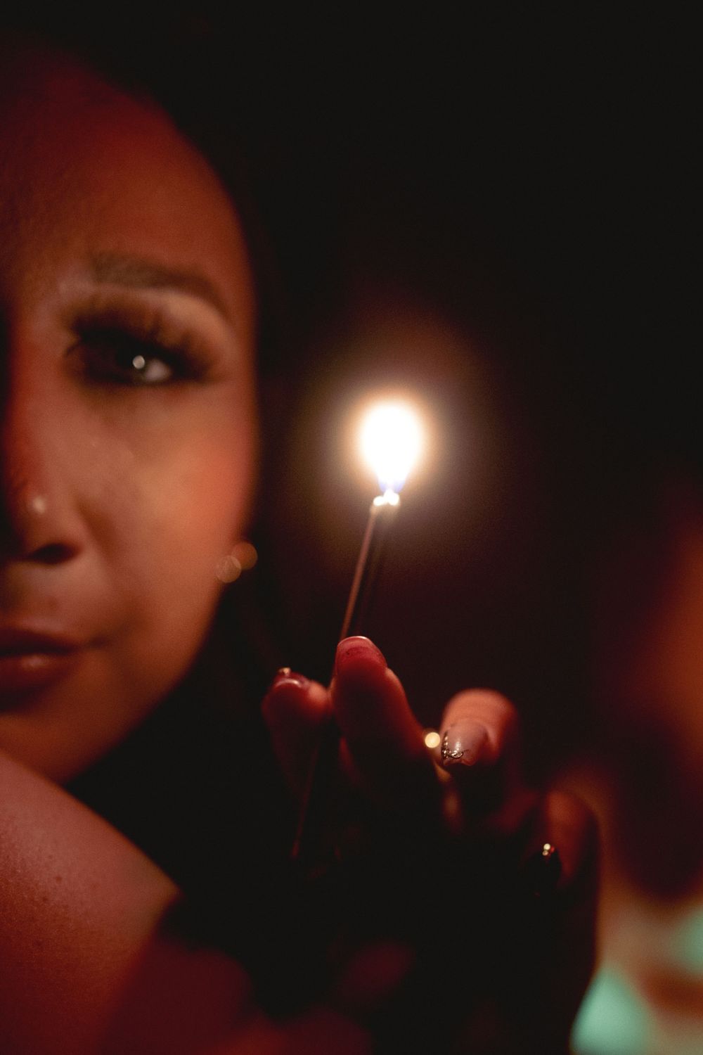 Dramatic closeup of a lit match against dark background with creative lighting.
