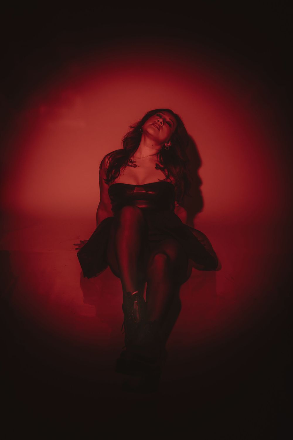 Artistic portrait with red backlight creating a dramatic silhouette in evening wear.