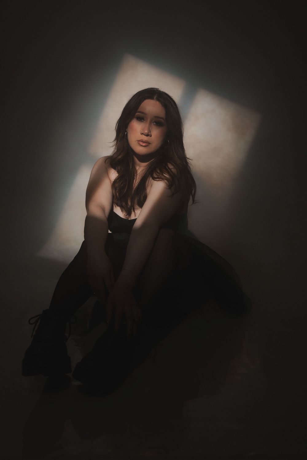 Atmospheric fashion photo with soft shadows and a flared black dress.