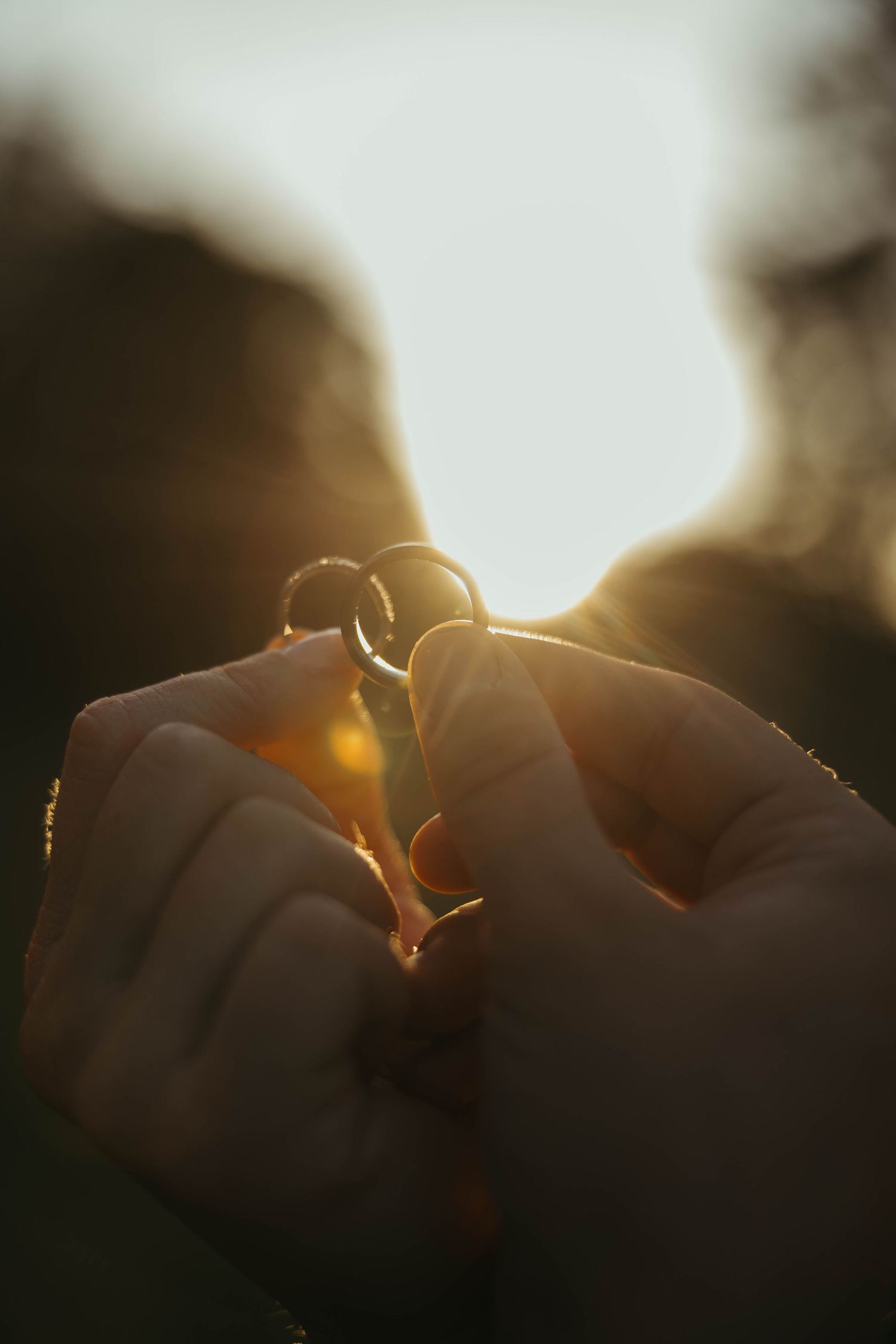 Silhouetted couple sharing an intimate moment at sunset in a romantic outdoor setting.