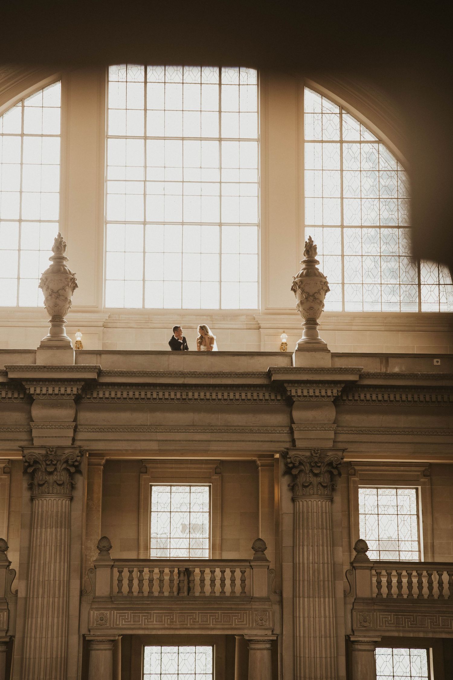 Historic building interior with grand architectural details and large arched windows.