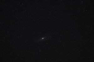 A bright comet or celestial object glowing against a dark starry sky.