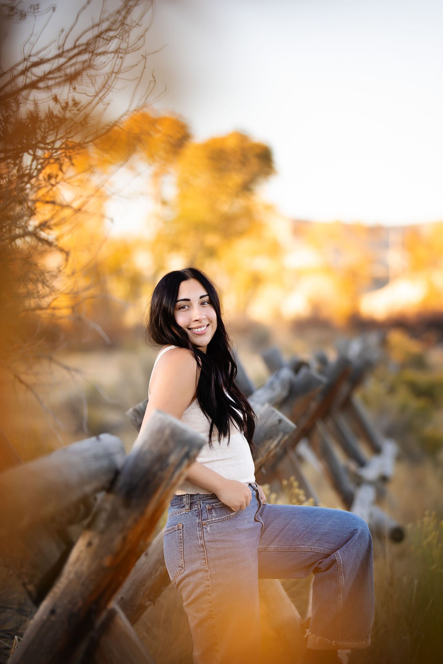 An autumn portrait near fallen logs with warm sunlight filtering through trees.