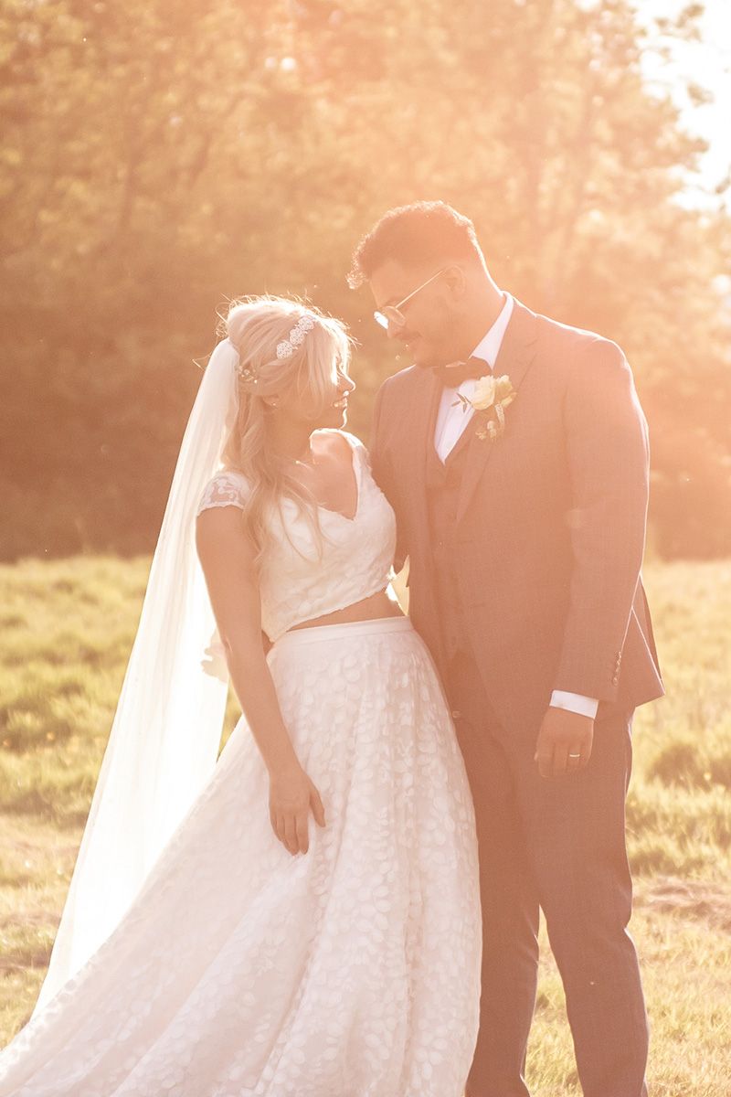 bride and groom walk together in the sunset in east sussex