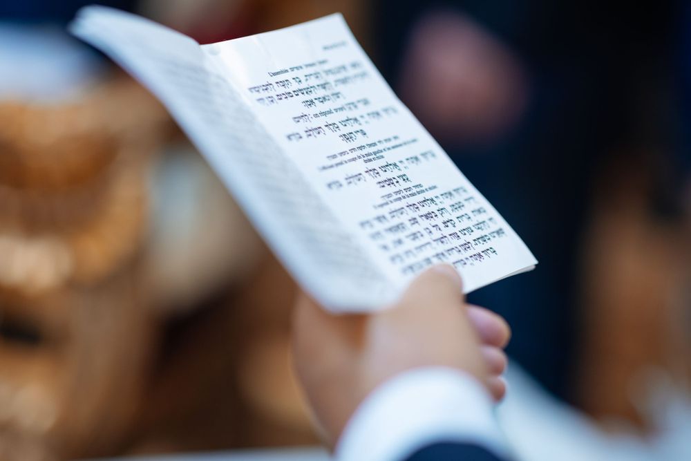 A close-up of Hebrew text on a white ceremonial document.