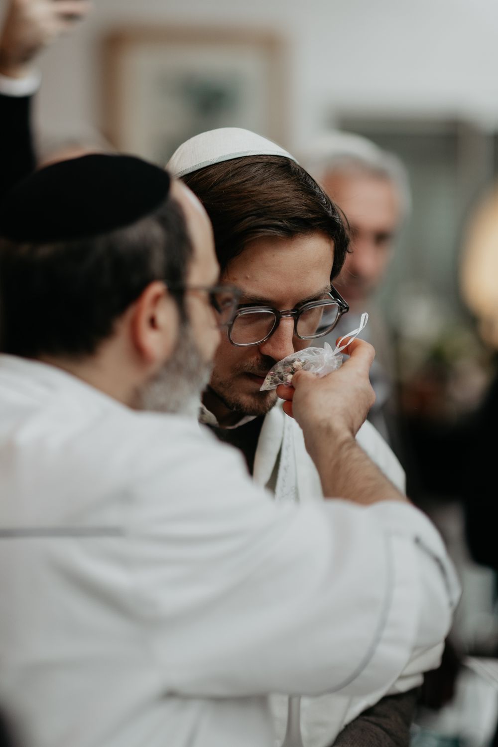 A sequence of close-up shots showing someone in a white garment wiping their eyes with a tissue.