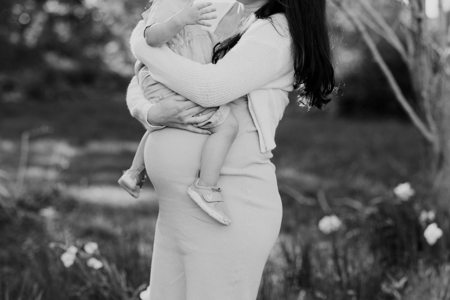 A tender embrace captured in black and white as a woman holds a small child.