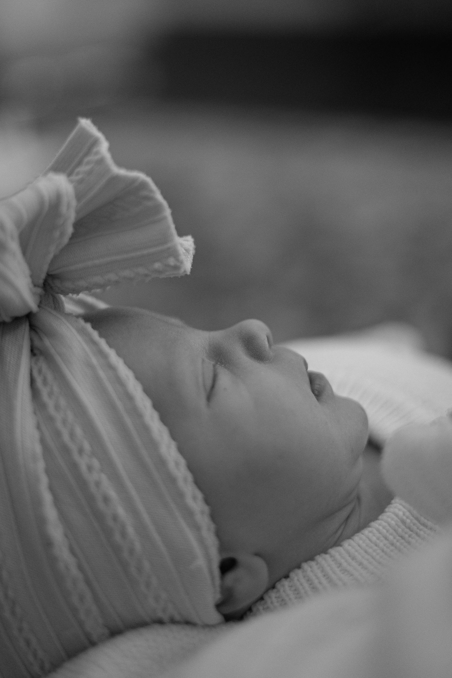 Black and white close-up series of a sleeping newborn baby wearing a knit cap.
