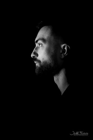 Black and White Side Headshot portrait of a man in studio. Jeff Fevens Photography.