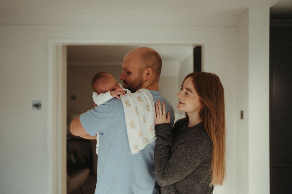 Family sharing a tender moment together in bright white modern home interior.