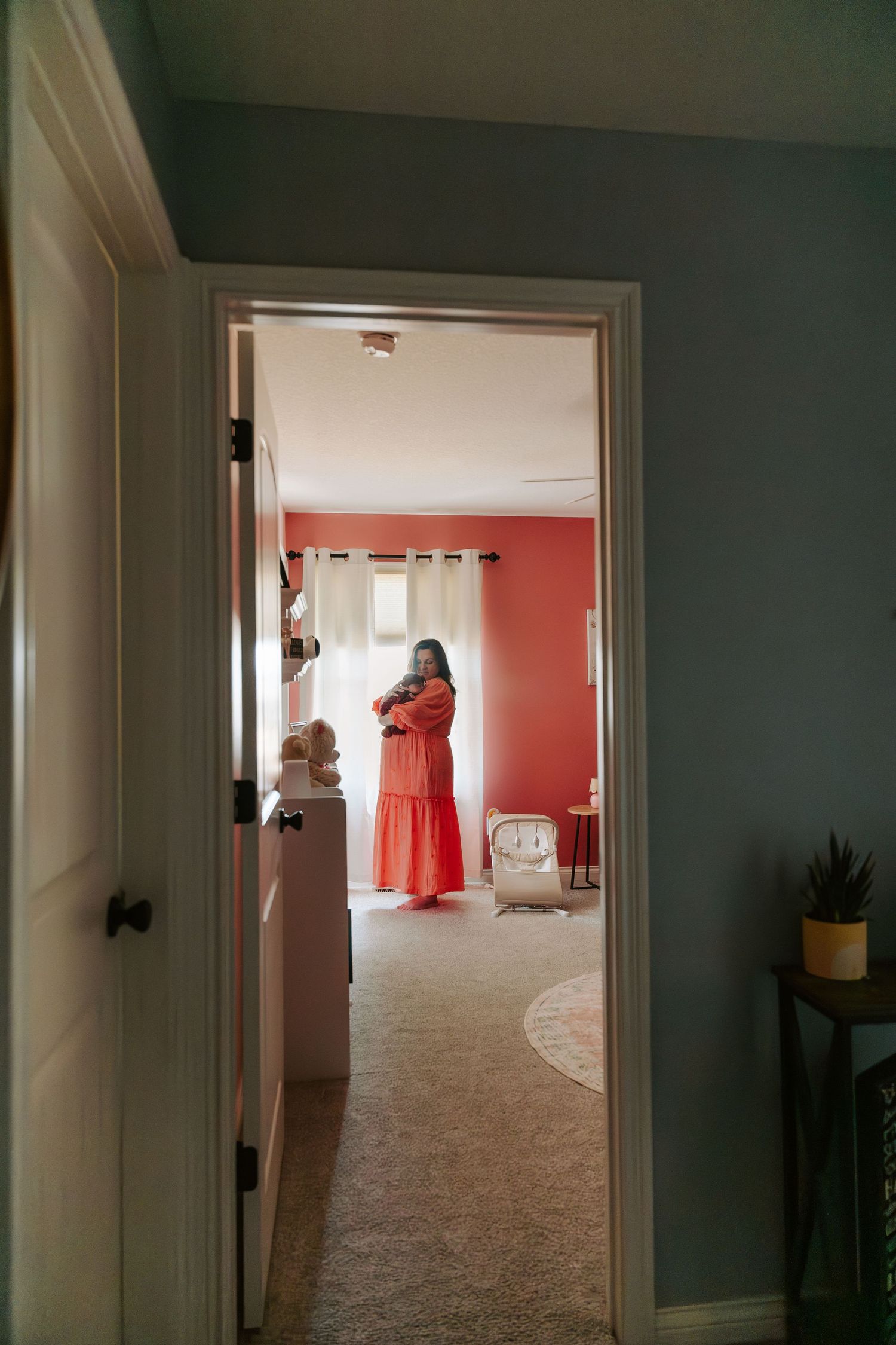 A sequence of interior doorways creates a long perspective view down a hallway with white walls and beige carpet.