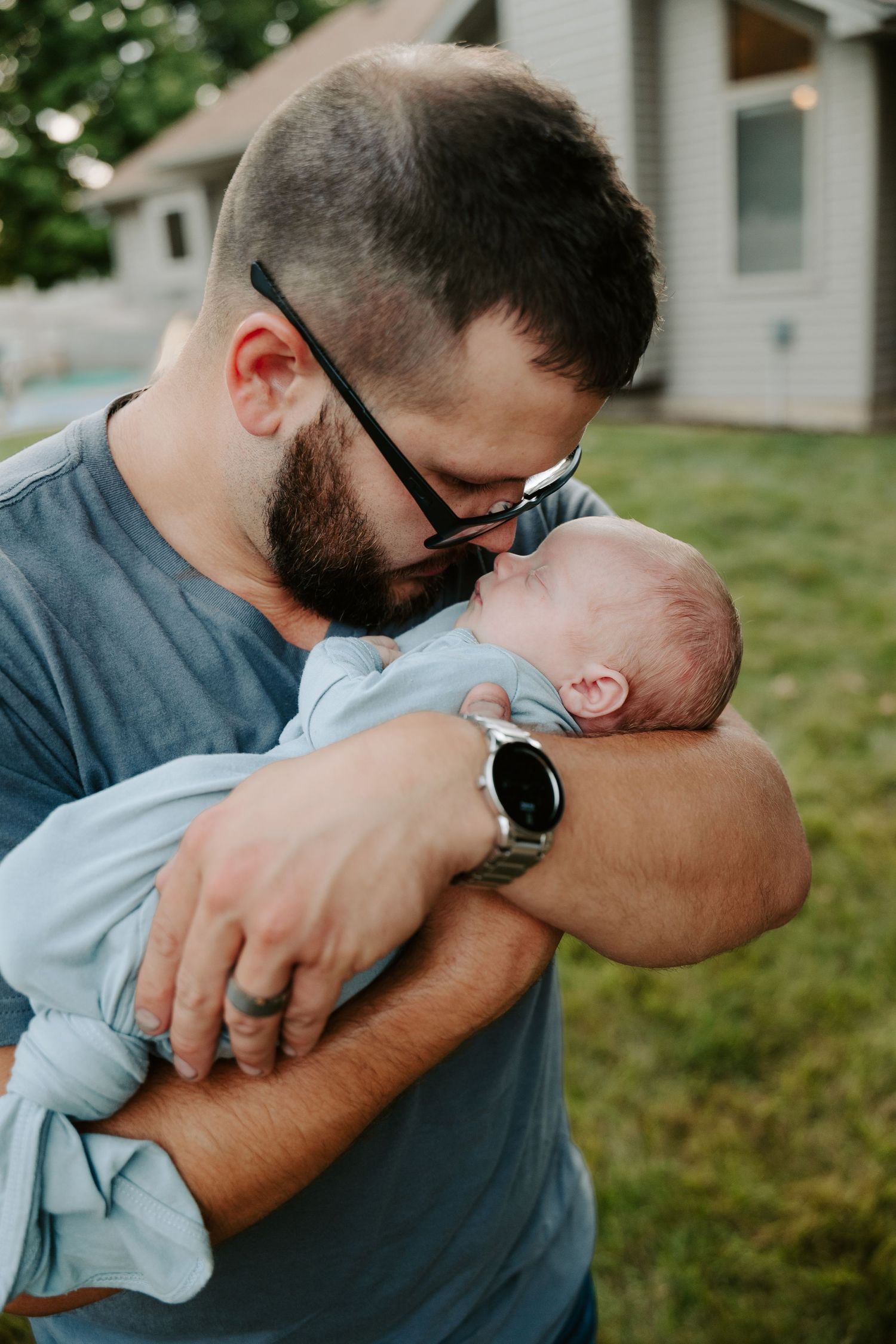A tender moment captured in a sequence showing a person embracing and comforting a small baby outdoors.
