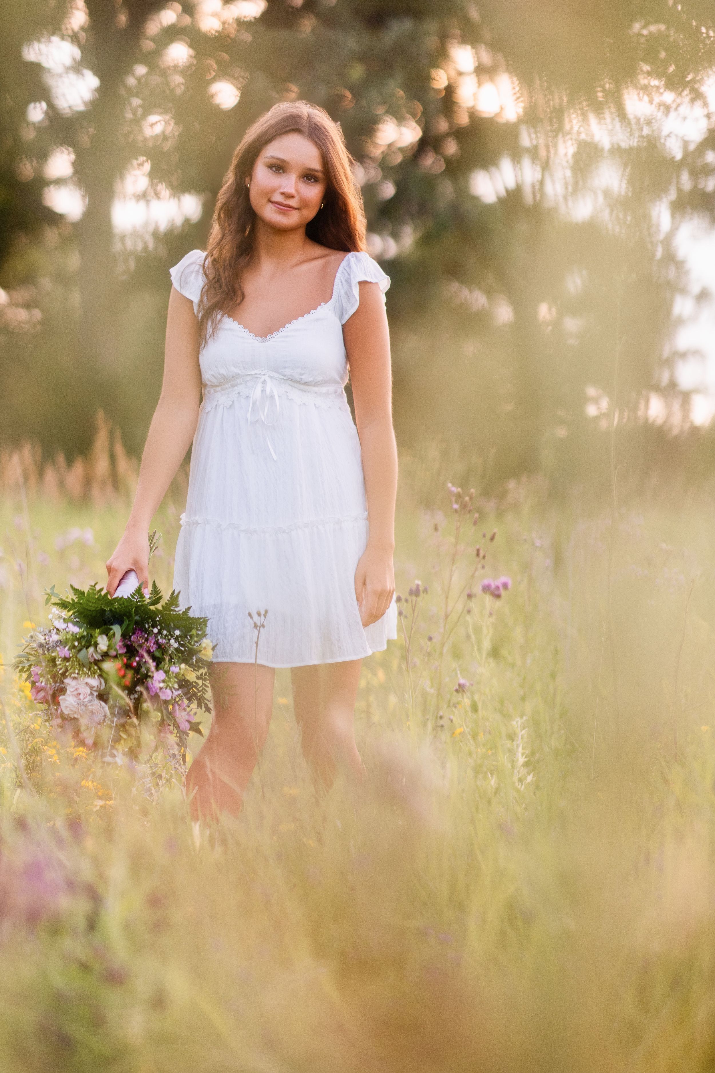 A soft dreamy portrait series shows a white sundress against tall grass in golden evening sunlight.