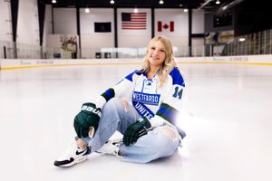White hockey skates glide across smooth indoor ice rink surface.