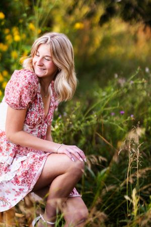 Sunset portrait session in a wildflower meadow wearing a floral pink dress.
