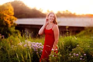 Summer portraits in a blooming wildflower field at golden hour wearing red.