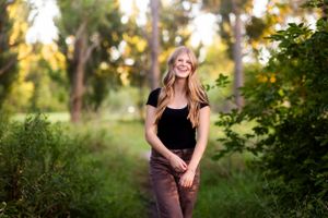 Natural light portrait session in a wooded area during golden hour.
