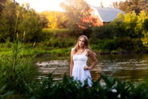 Waterfront portrait session at sunset with natural lighting and scenic backdrop.