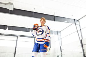 Hockey players in blue and white uniforms on ice during game.