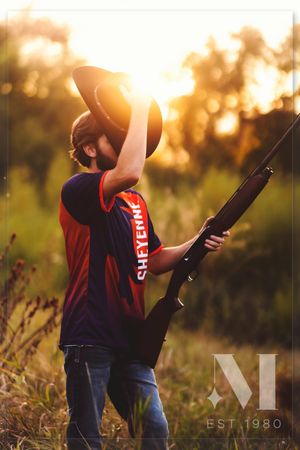 A sunset silhouette photo shoot with someone holding a guitar in a field with golden light.