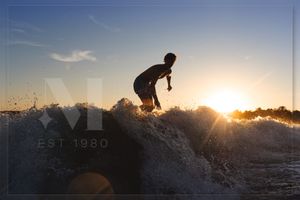 Silhouette of a person jumping on rocks at sunset creating a dramatic outdoor adventure scene.