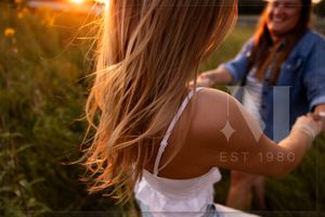 Hair blowing in wind during sunset photoshoot in natural outdoor setting.