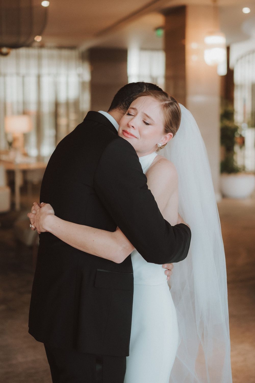 A tender wedding moment captured in multiple frames showing the couple embracing in a warmly lit indoor setting.