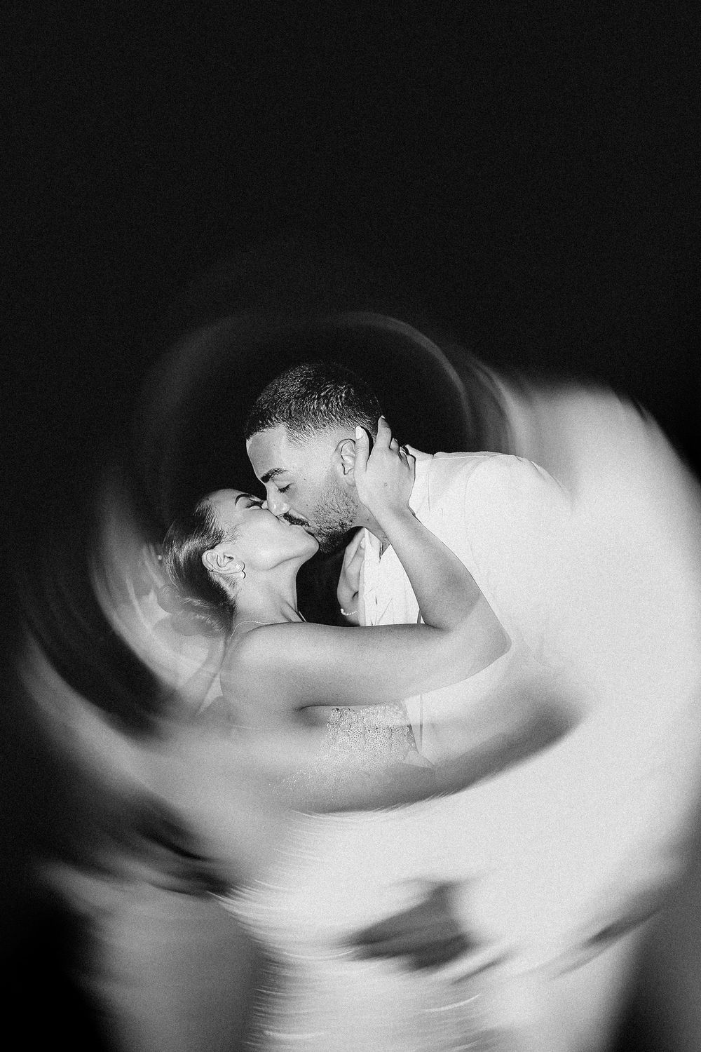 Abstract black and white motion blur photography creates ethereal swirling patterns in darkness.