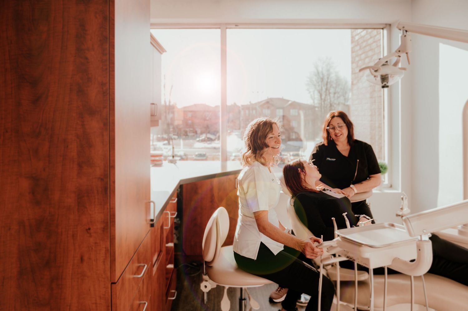 Two people sharing a lighthearted moment in a dental office setting.