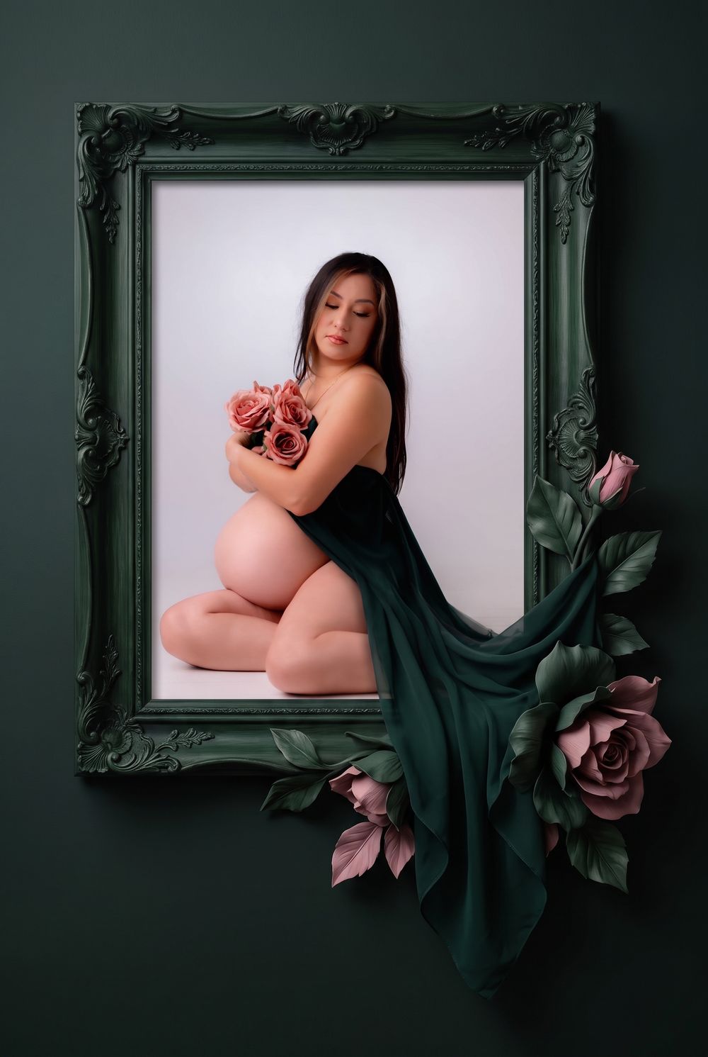Pregnant woman kneeling with pink roses in a green ornate frame with floral decor, elegant maternity portrait photography.