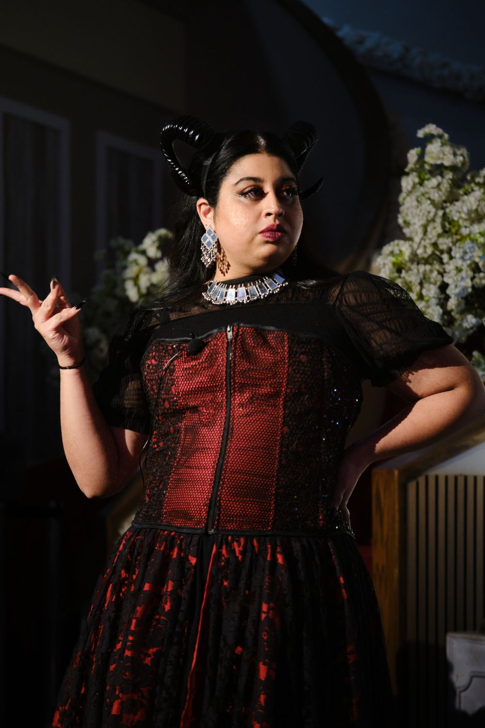 A dramatic fashion photo series showing a red and black Victorian-style dress against a dark background.
