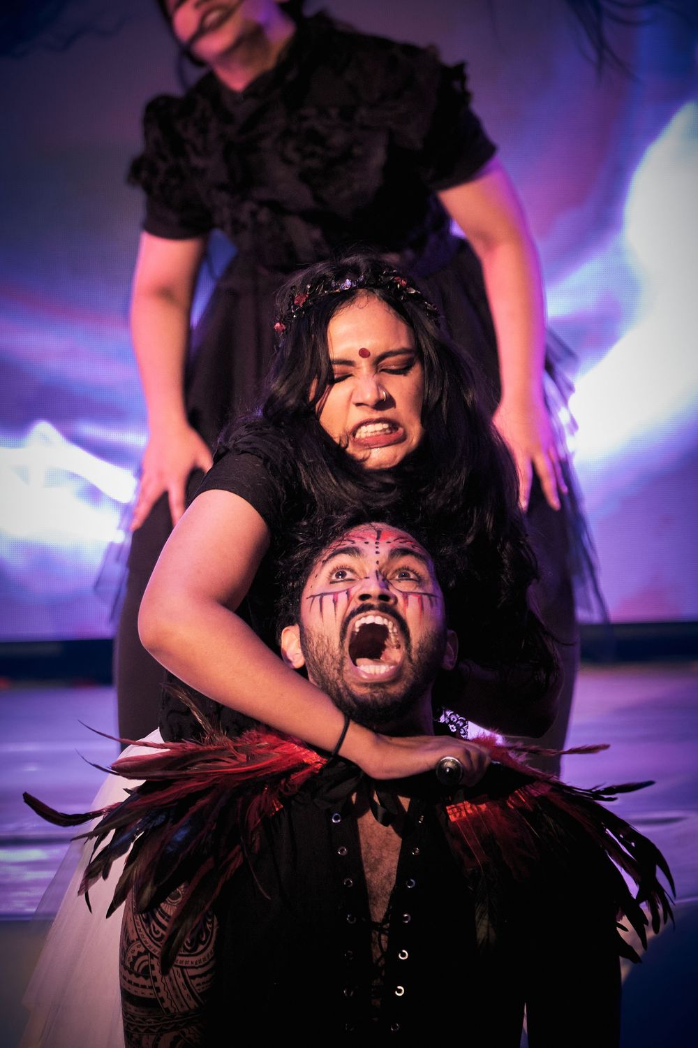 Dramatic performance art sequence showing expressive movements and emotions under purple stage lighting.
