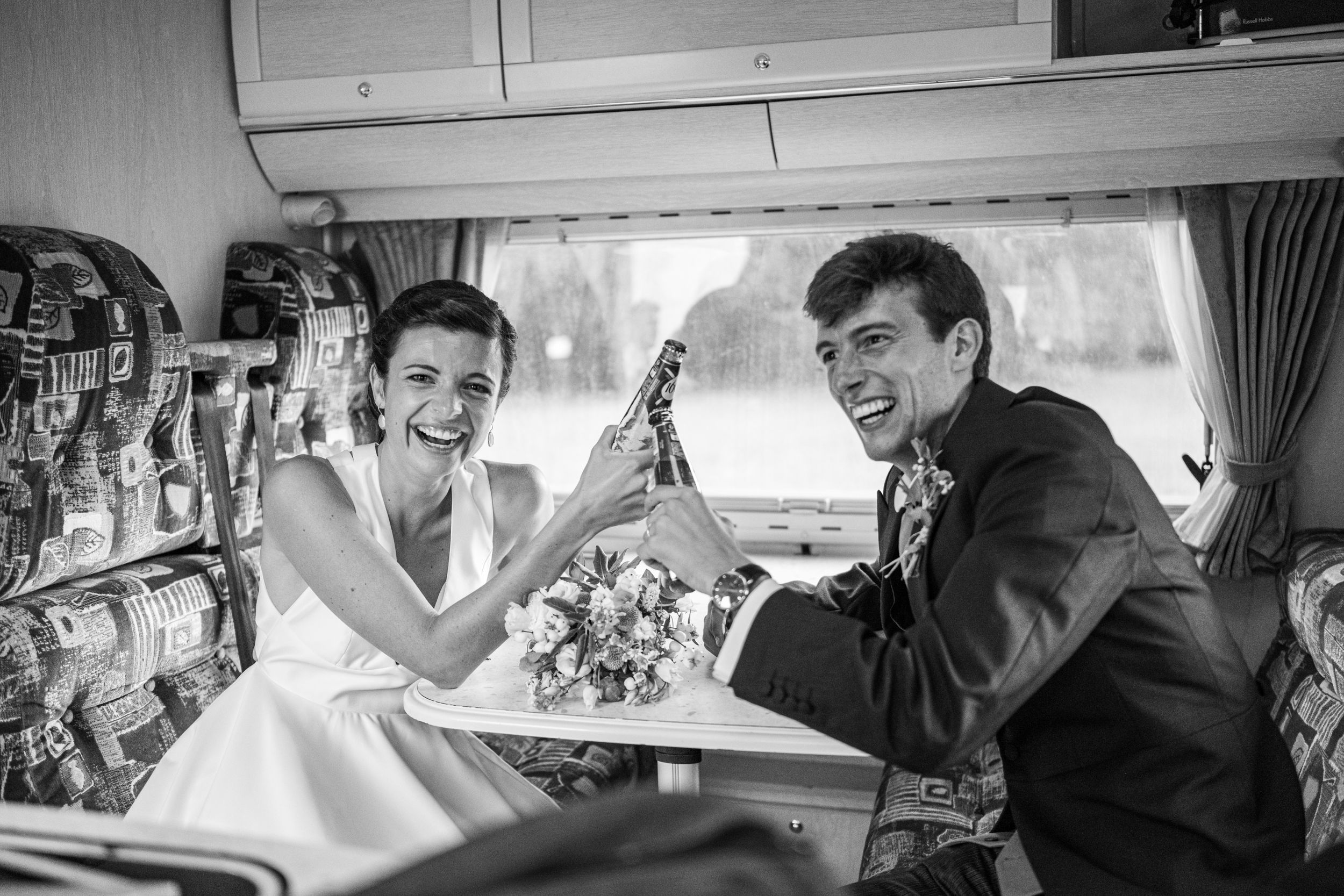 A black and white photo of a joyful moment inside a vintage vehicle.