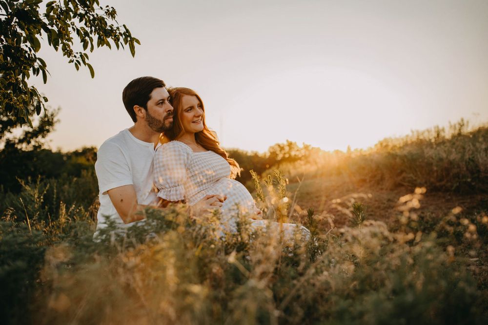 Romantic maternity portrait in a wildflower field at golden hour.