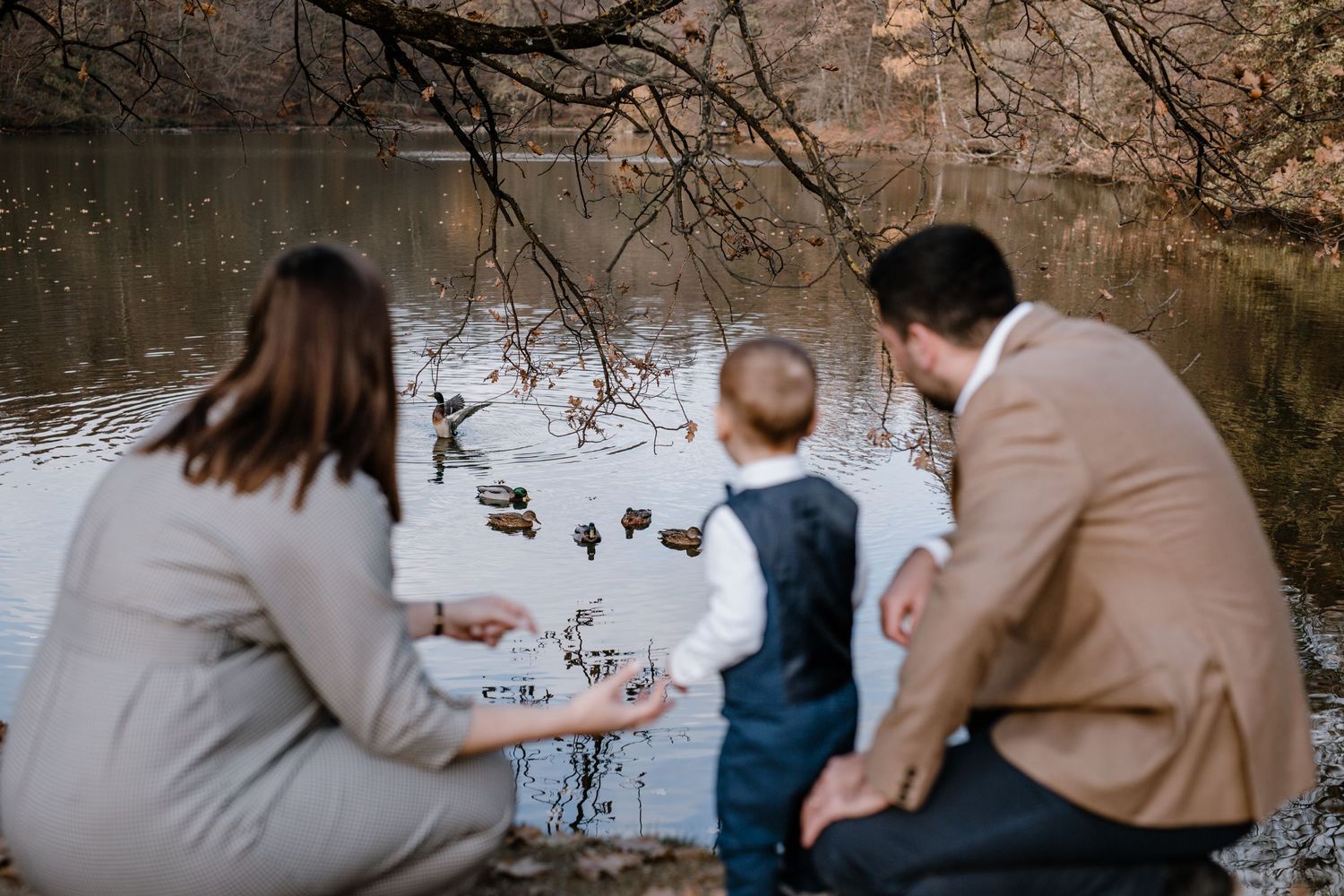 Family bonding by the lake, showcasing a candid and authentic moment as they walk and explore the lakeside together.