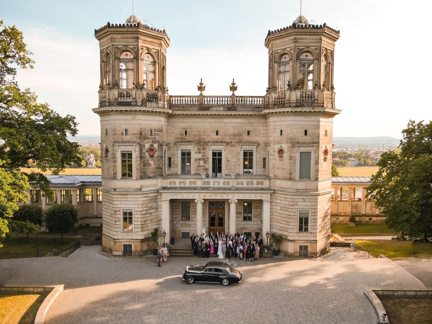 Panoramic view of a majestic stone palace with classical architecture and twin towers. Organized wedding by MyCastleWedding | Dresden.