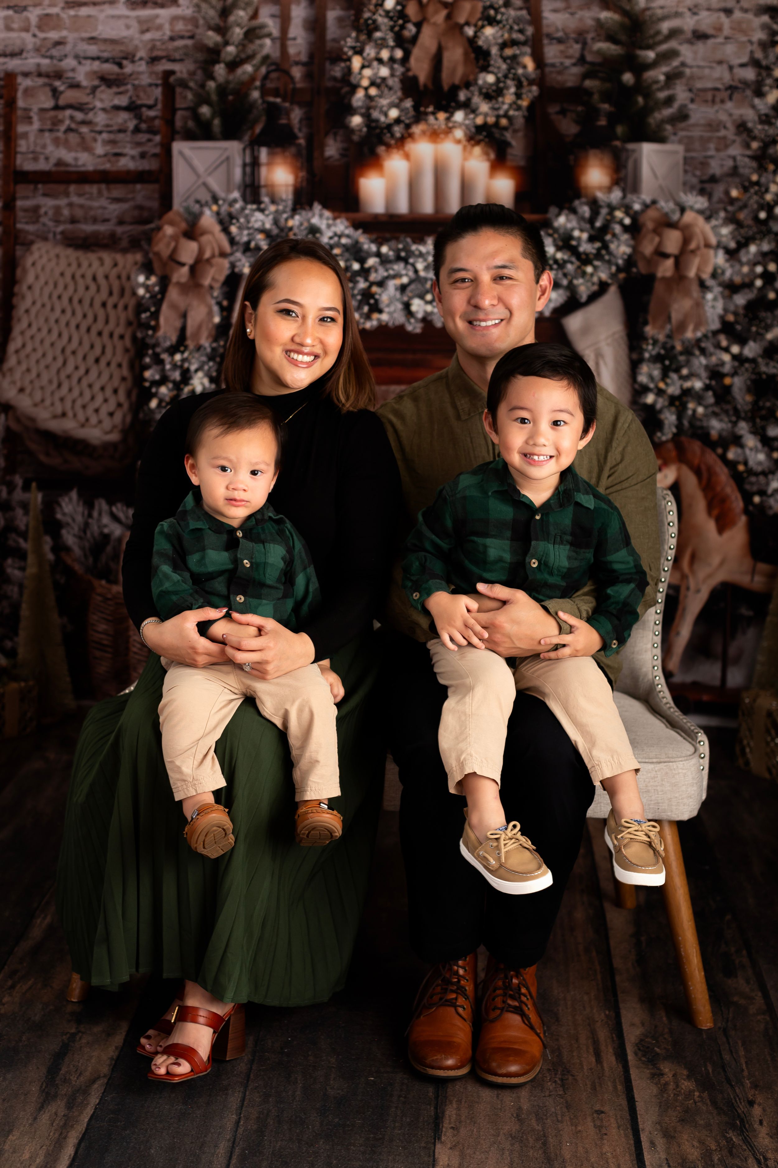 Professional family holiday portrait with coordinated outfits against Christmas decor.