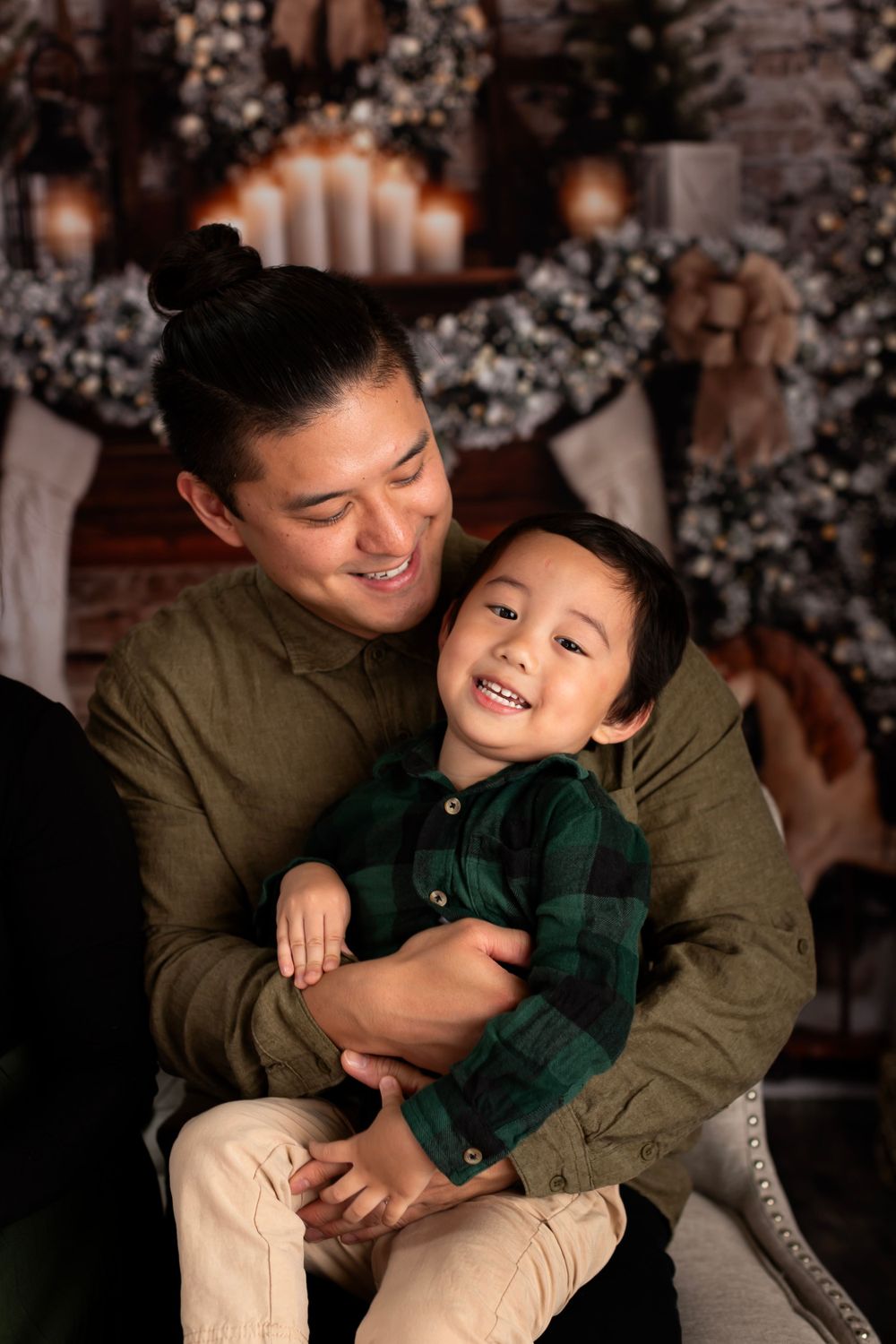 Candid holiday moment captured against a backdrop of Christmas lights and decorations.