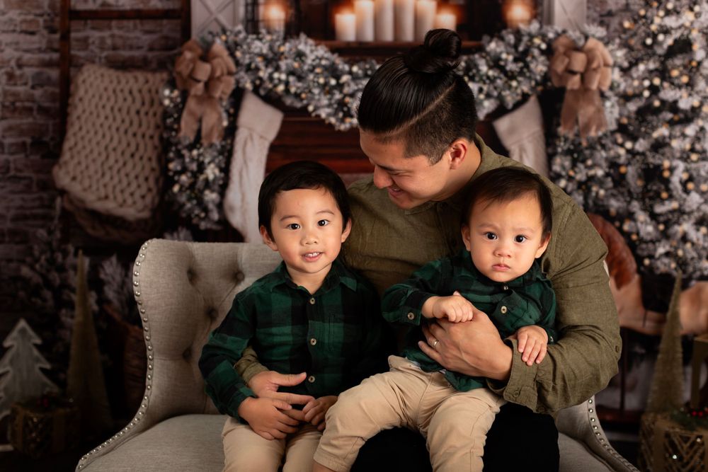 Warm holiday portrait against a rustic Christmas setting with glowing candles and flocked garland.