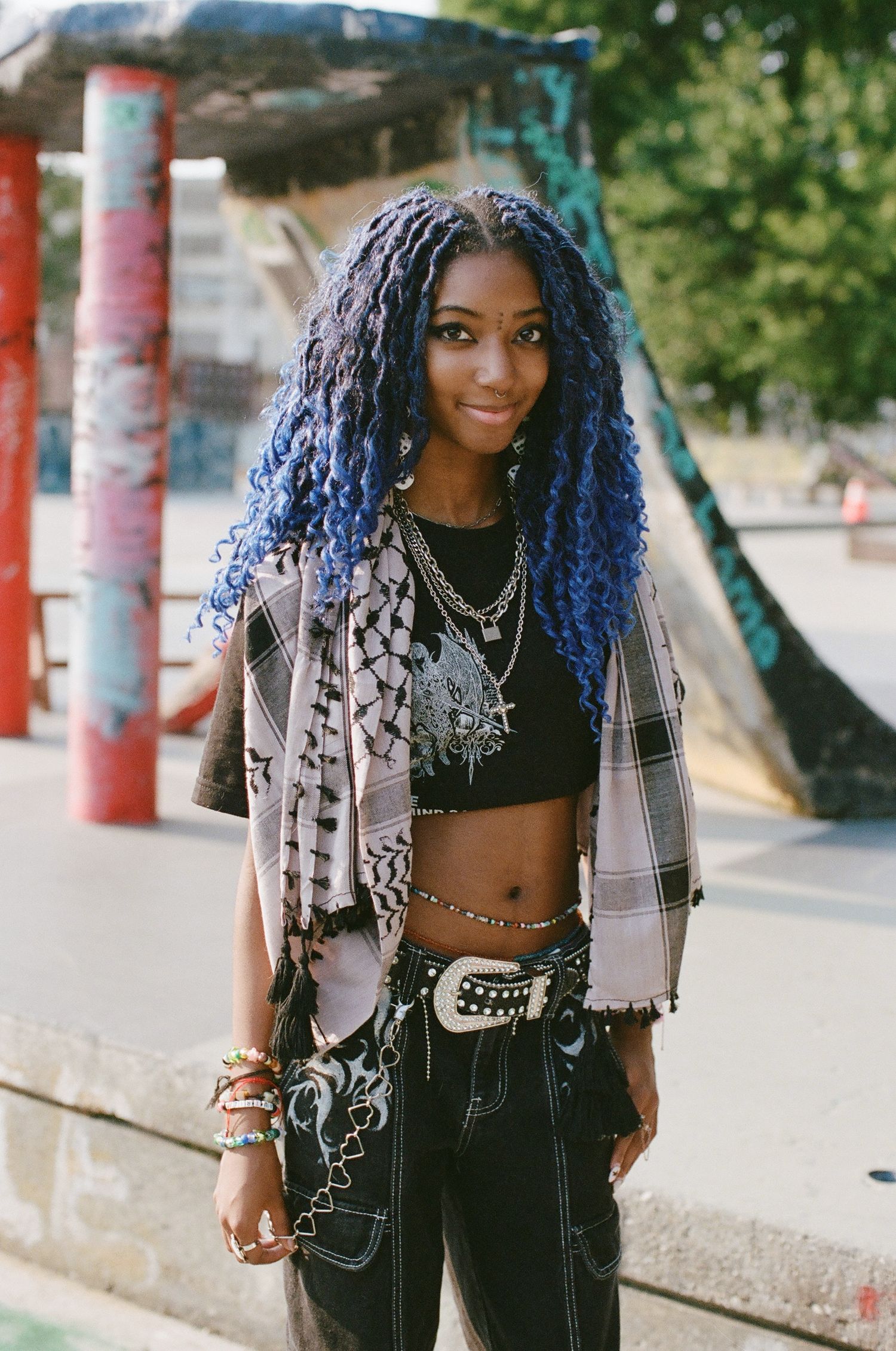 Urban fashion shoot featuring blue hair and alternative style against colorful painted columns.