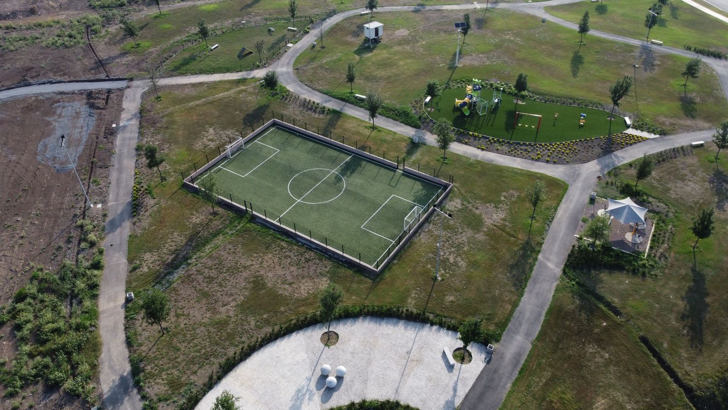 Aerial view of sports facilities including soccer field and recreational areas in urban park.