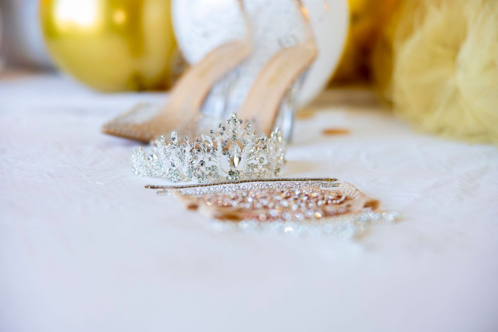 Delicate crystal wedding tiara and jewelry displayed on white surface.