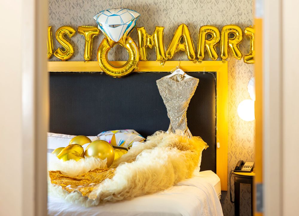 Illuminated 'JUST MARRIED' sign with diamond ring design in gold and white decor.