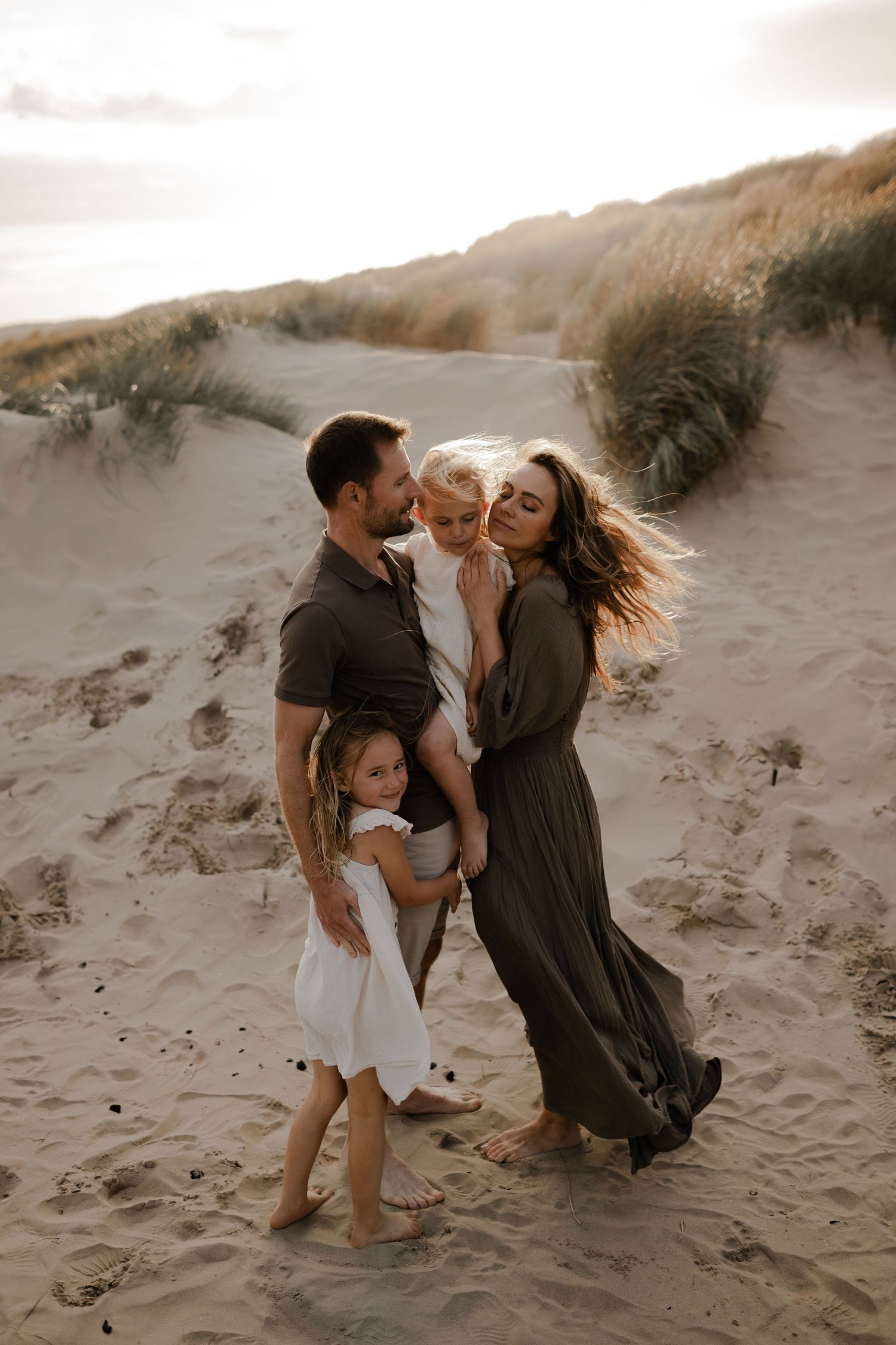 A family standing on a beach with their  three children during a family photo session with Forever Ours Photography